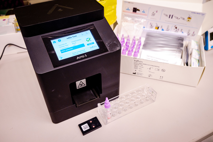 COVID-19 antibodies test kits (right) and the digital reader device (left in black), developed by a joint team by SMART and NTU Singapore