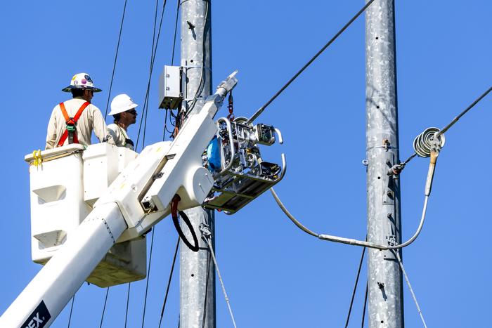 A robot is prepared to coat a power line at ORNL's PCAT test facility.