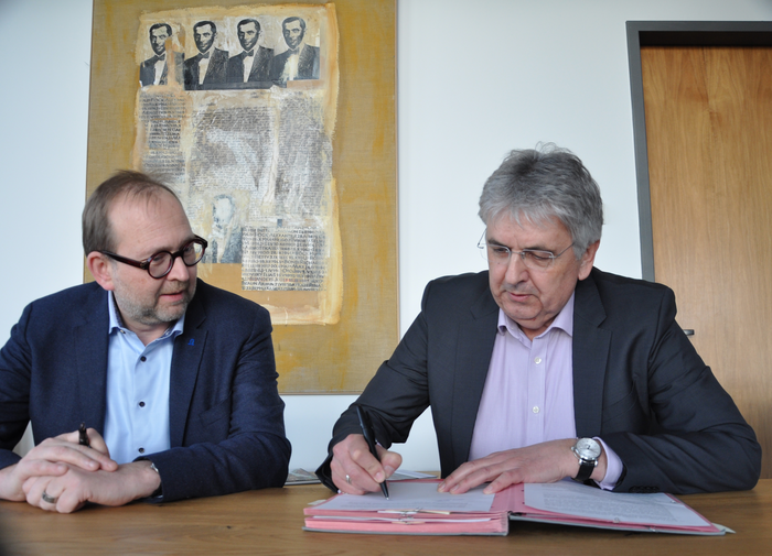 Dr. Breuer signs his employment contract with Prof. Dr. Schleiff