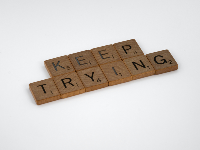 “Keep trying” spelled out in scrabble tiles.