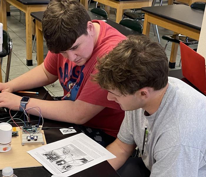 Agriculture students programming microcontroller with ChatGPT