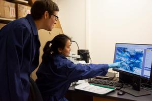 Sarah Batterman and Michelle Wong look at a microscopic image of mycorrhizal fungi.