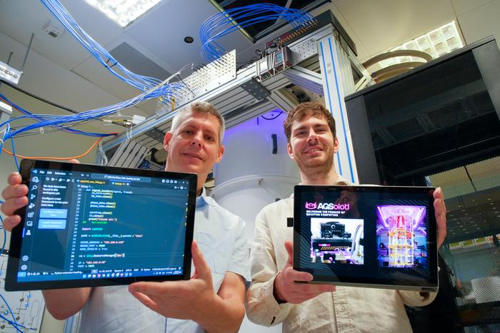 NTU Assoc Prof Rainer Dumke (left) with AQSolotl CEO Patrick Bore (right), with their Chronos-Q quantum controller (in black) seen in the top right corner of the quantum computer at NTU.