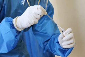 A laboratory worker takes a swab test.