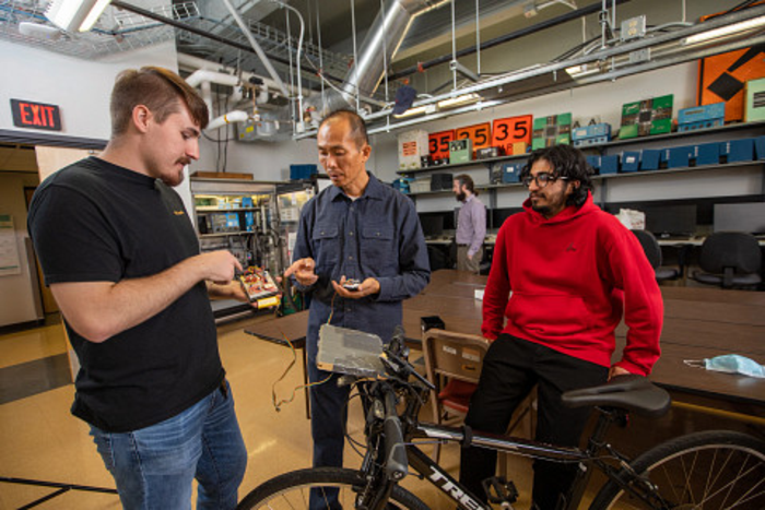 Team of NAU engineers working on instrumented bicycle