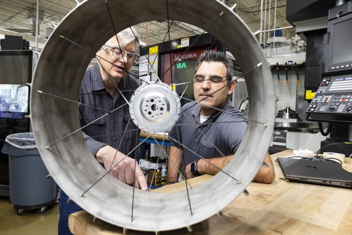 NASA mechanical design engineer Richard Hagen and ORNL researcher Michael Borish inspect a lunar rover wheel prototype that was 3D-printed at the Manufacturing Demonstration Facility.