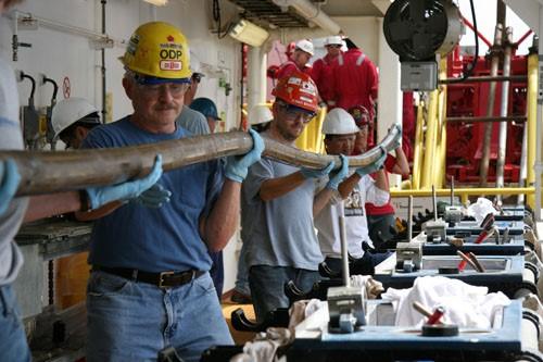 Scientists Carrying a Sediment Core on the Catwalk
