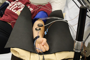 A study participant sits in James Lang's lab at Iowa State during a microvascular test.