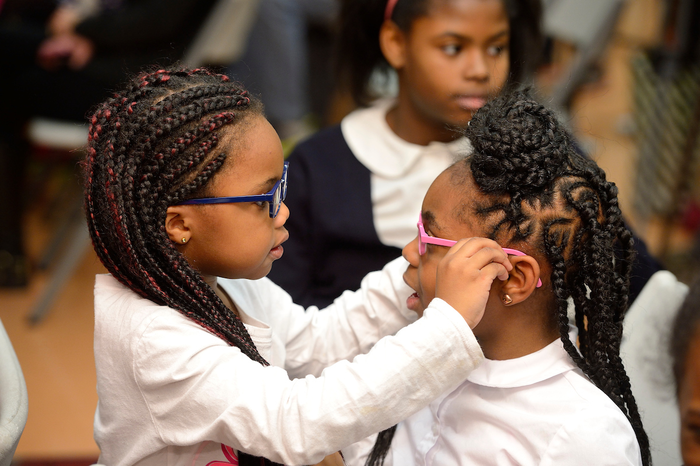 School children trying on new eyeglasses