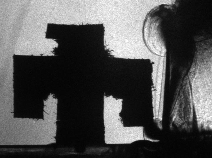 Detonation of a thin explosive film with a barrier