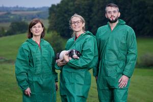 The team (left to right) in hygienic protective clothing with piglets: