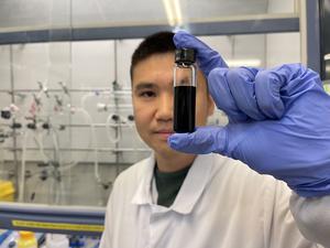 Lucheng Peng in the lab holding a solution of quantum dots