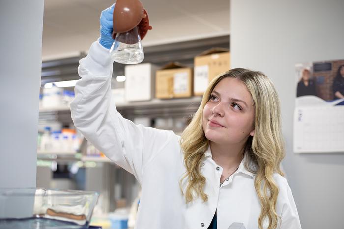 Gianna Frank mixing solutions in a beaker.