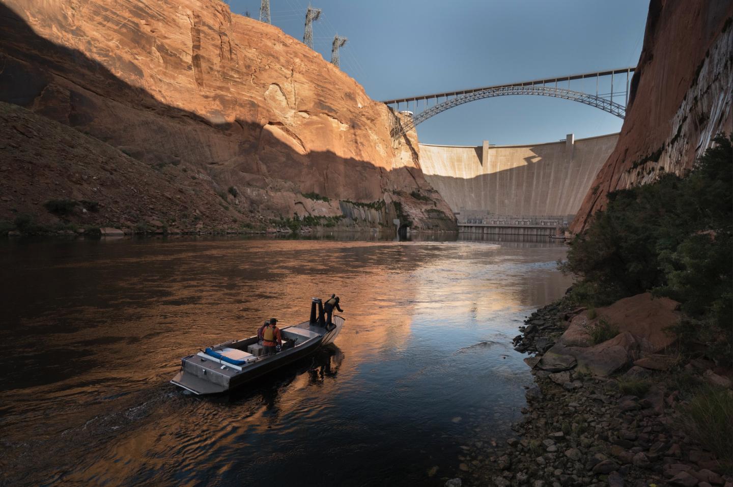 Researchers in Boat in Front of Dam