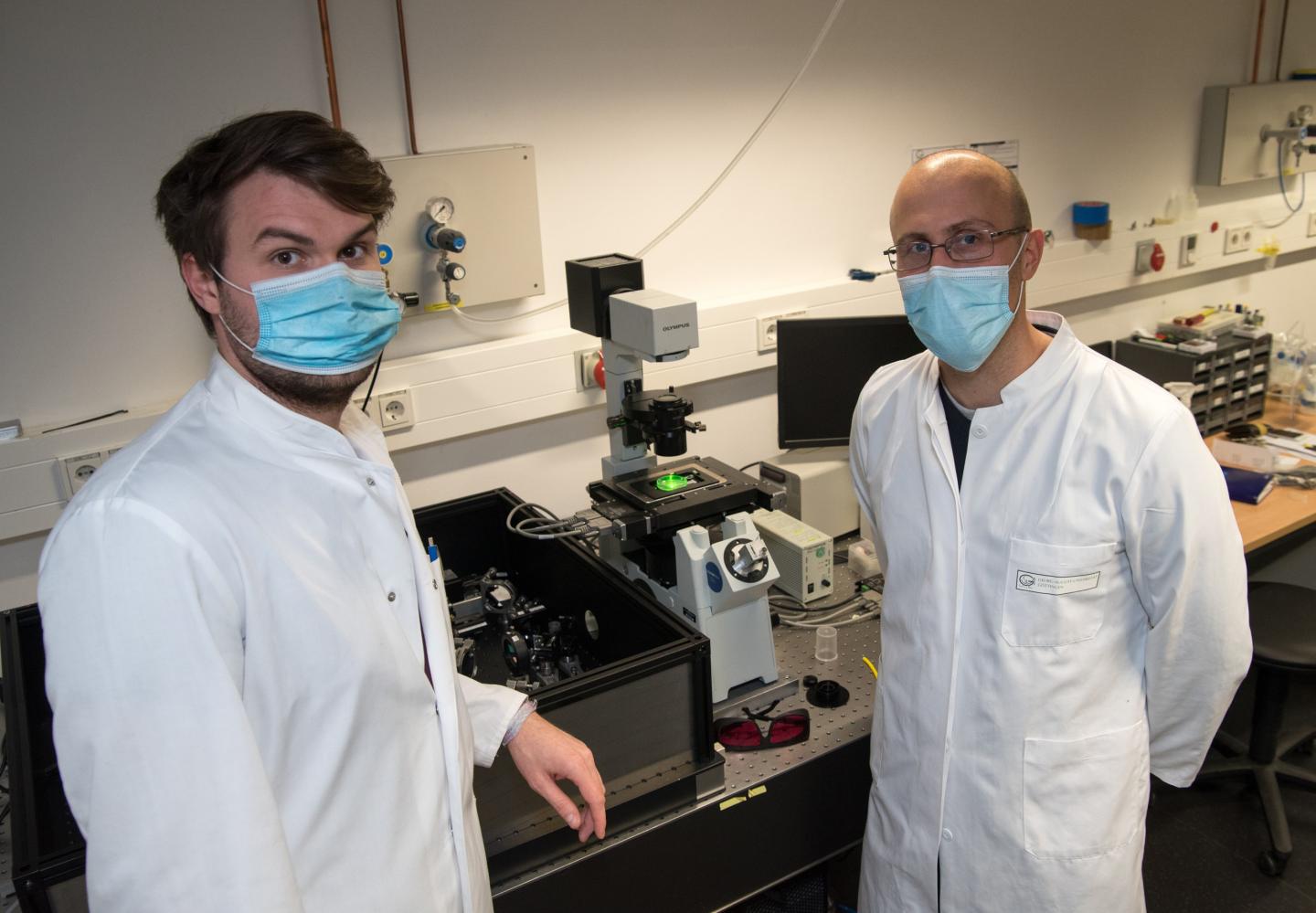 Researchers wearing masks in lab