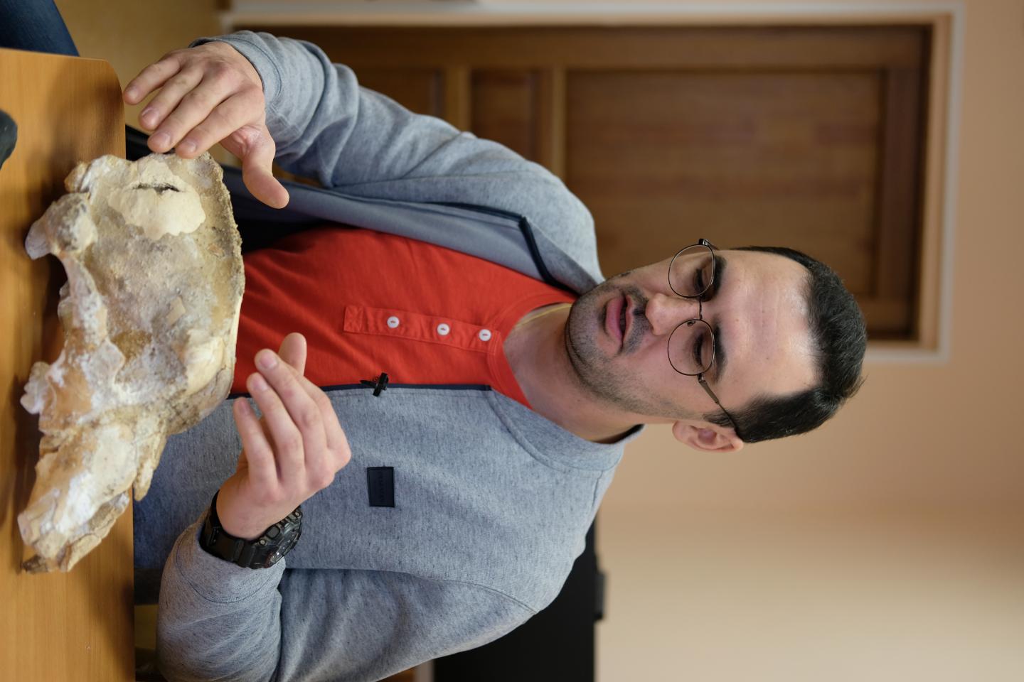 Dmitry Gimranov and the skull of a small cave bear from the Imanay Cave.