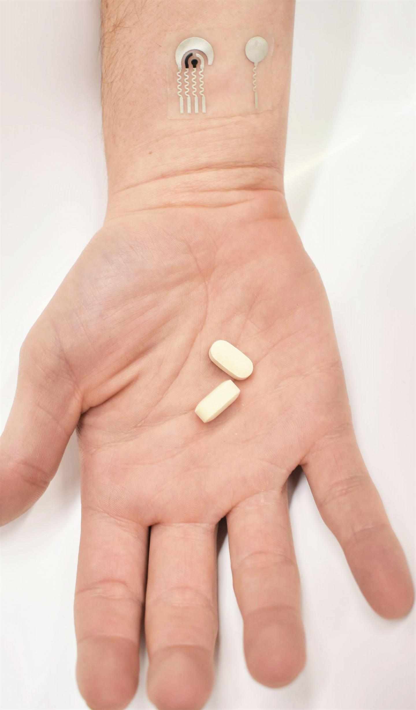 Hand with Vitamin C Pills and Sensors