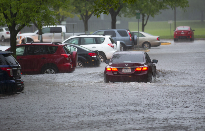 A car drives through a flooded parking lot in Ames, IA in 2018.