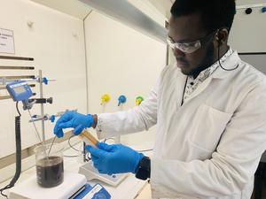 Researcher removing heavy metal from treated sewage material in the lab