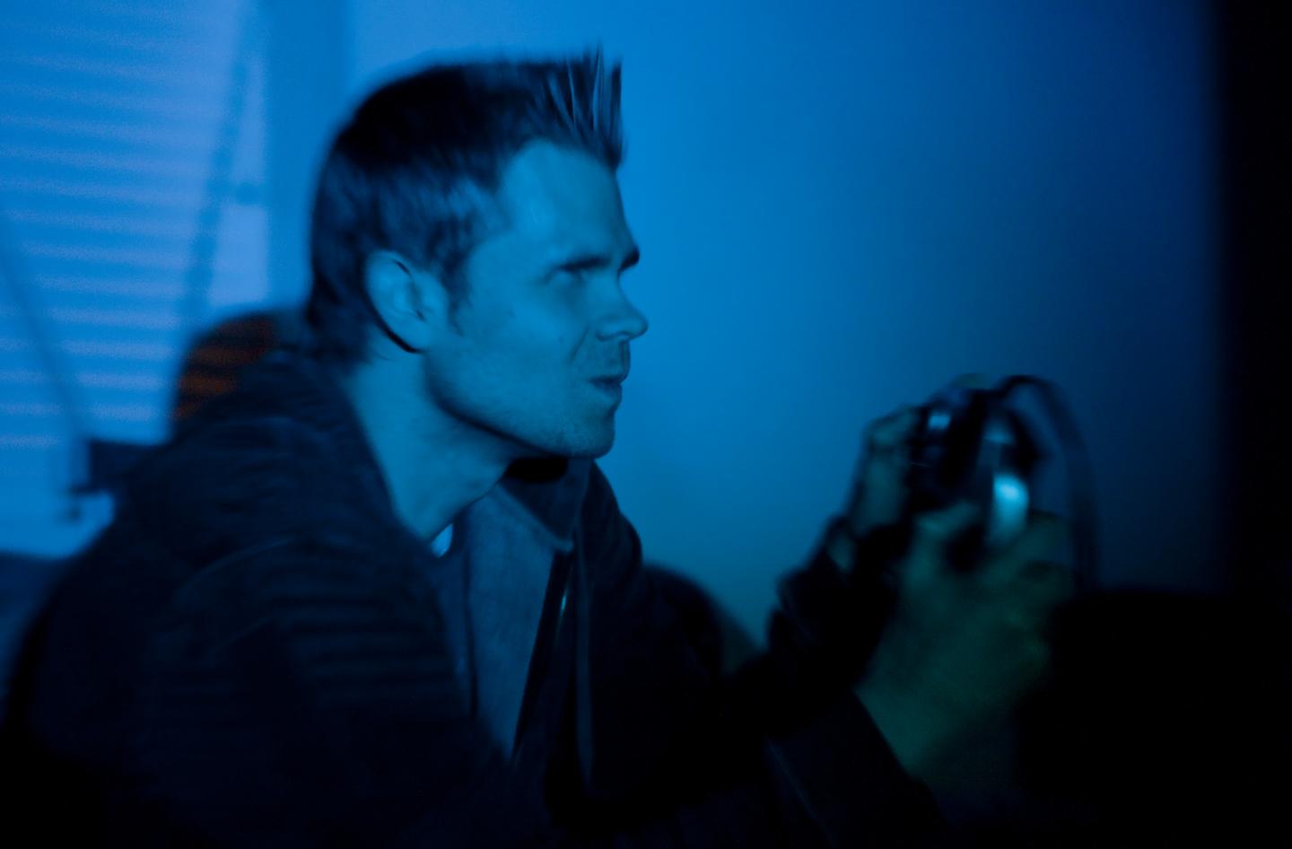 Man Playing Video Games in Dark Room
