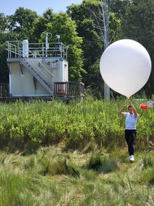 Researcher Claudia Bernier walks a weather balloon out