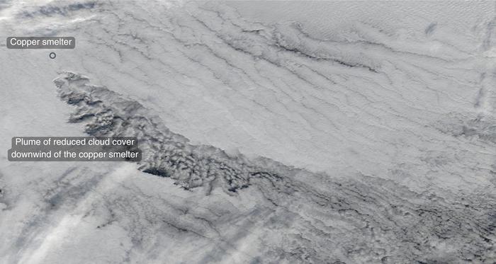 The satellite image shows a plume of reduced cloud cover downwind of the Rouyn-Noranda copper smelter in Canada.