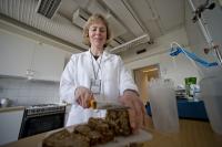 Researcher Anne Nilsson cutting up barley bread