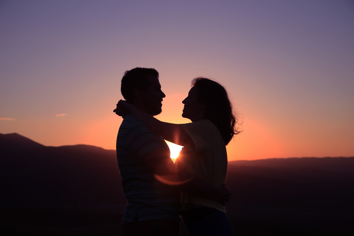 A silhouette of a couple standing together.