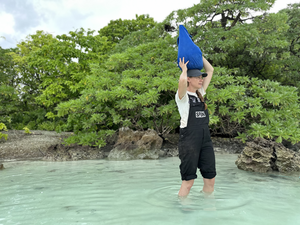 Toby Kiers carries supplies to a sampling site on an islet