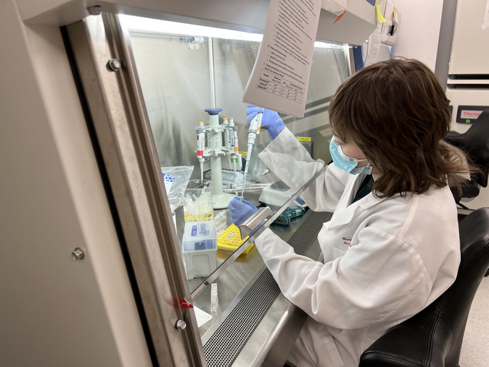 A member of the Barreiro lab works in the tissue culture hood