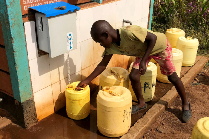 Child retrieves chlorine treated water from a rural kiosk in Kenya