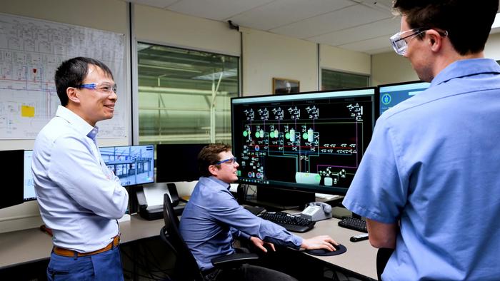 Bo Feng discusses research with engineers in the METL facility