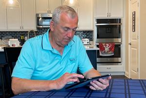Frank Rupnik, who has been diagnosed with early-stage Alzheimer’s disease, answers cognitive ability questions on a tablet at his home.
