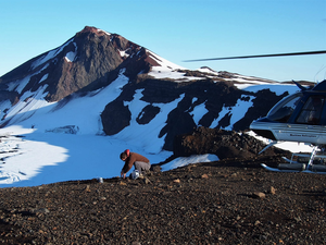 Dan Rasmussen, Peter Buck Fellow at the Smithsonian’s National Museum of Natural History, collects volcanic ash samples from the rim of the summit caldera on Akutan Volcano in 2016.