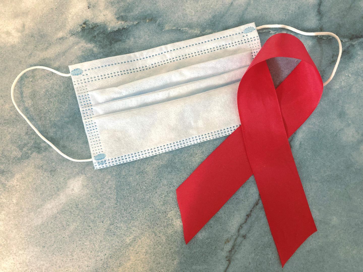 A surgical mask and an HIV/AIDS awareness ribbon.