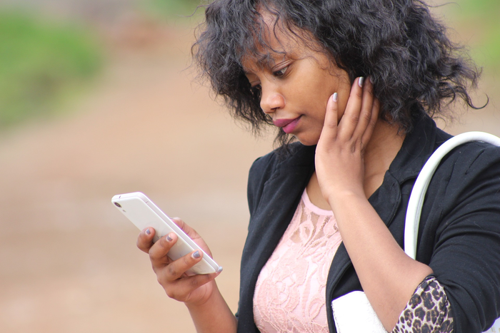 African woman checking phone