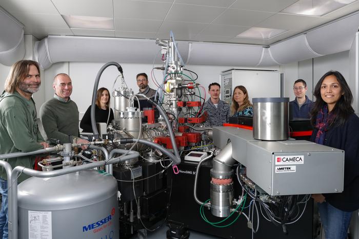 The research team in front of the CryoNanoSIMS instrument.