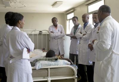Ethiopian Medical Students Gather and Discuss around Patient Bed in Hospital