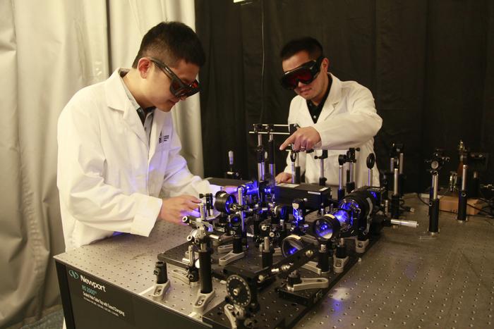 Researchers with optical setup