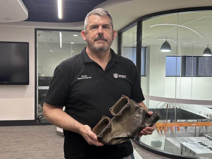 Bruce McLean and the original exhaust manifold from the AA810 Spitfire