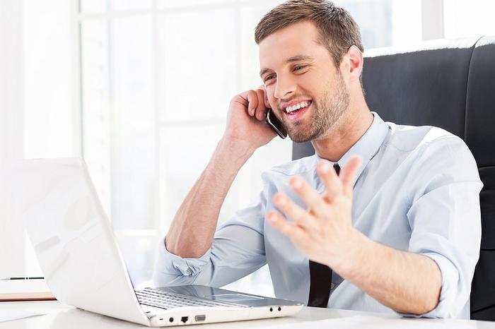 Man at computer and talking on phone