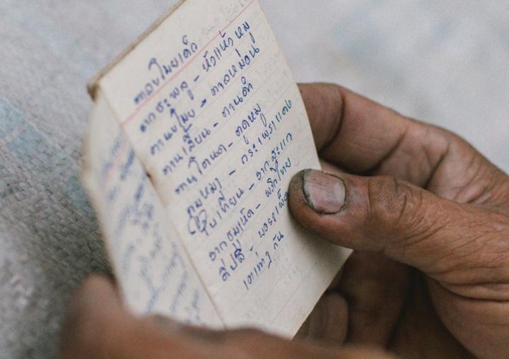 A Thai villager studying a formulary for herbal medicine.